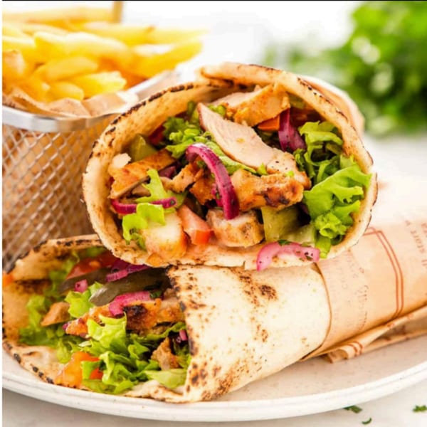 Two T3END shawarma wraps filled with chicken, lettuce, and red onions, with fries in the background.